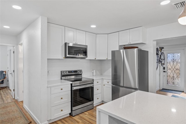 kitchen featuring white cabinets, light wood-type flooring, and stainless steel appliances