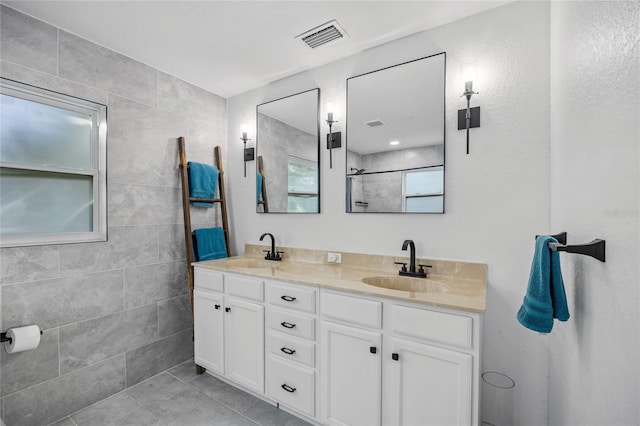 bathroom with tile patterned floors, vanity, and tile walls