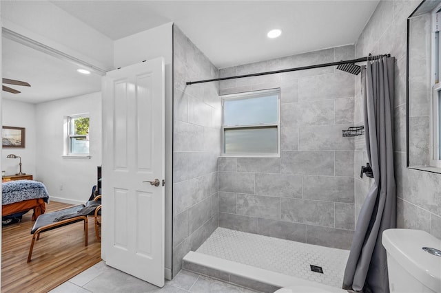 bathroom with hardwood / wood-style floors, toilet, walk in shower, and ceiling fan