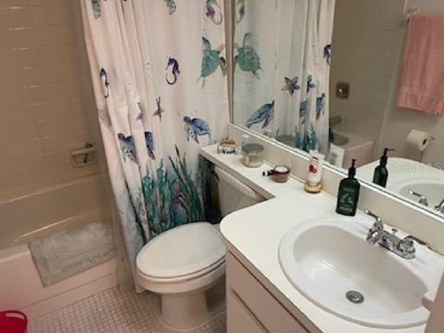 full bath featuring toilet, vanity, shower / bath combo with shower curtain, and tile patterned floors