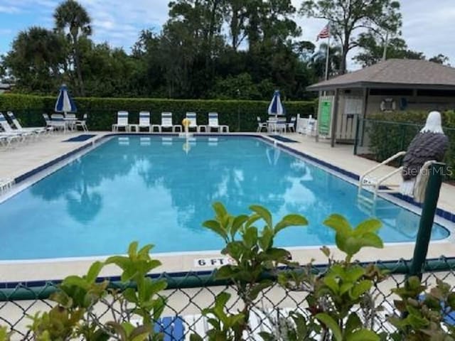 pool featuring fence and a patio