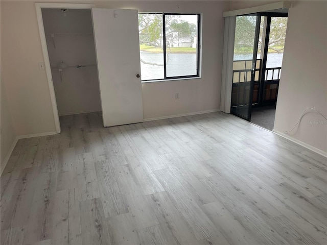 unfurnished room featuring light wood finished floors and baseboards