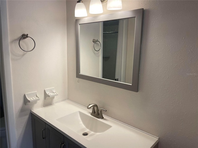 bathroom featuring a textured wall and vanity