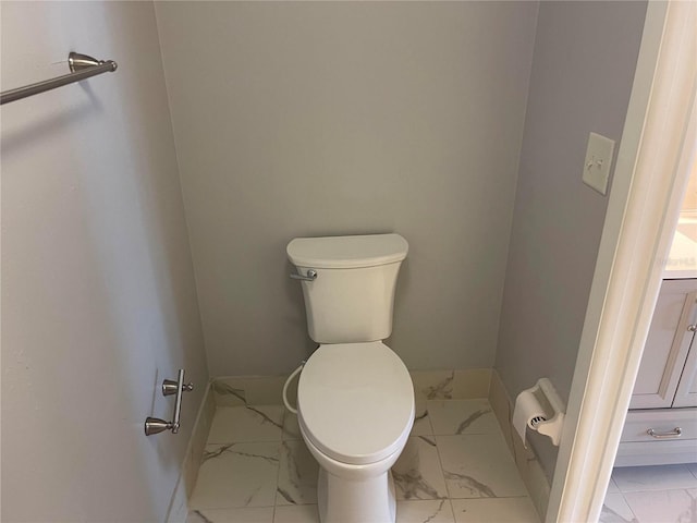 bathroom with marble finish floor, vanity, and toilet