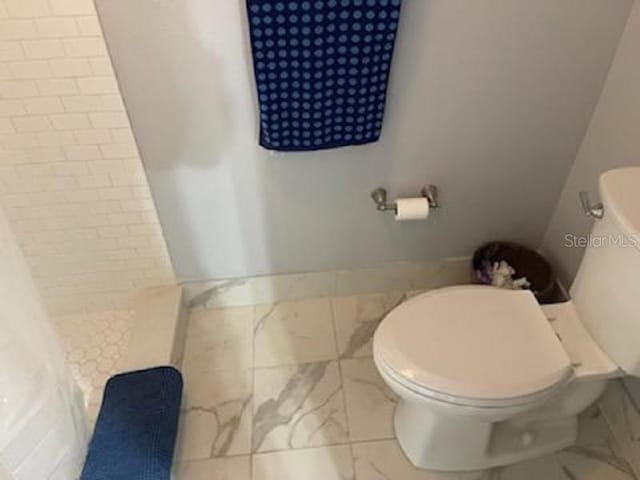 full bathroom with a shower stall and toilet