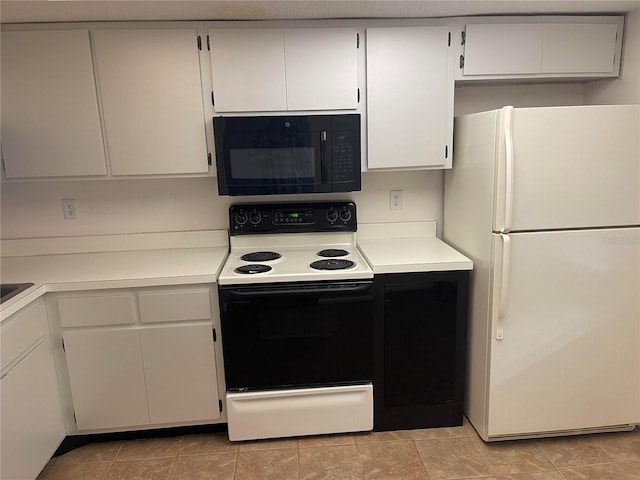 kitchen featuring black microwave, electric range oven, light countertops, and freestanding refrigerator