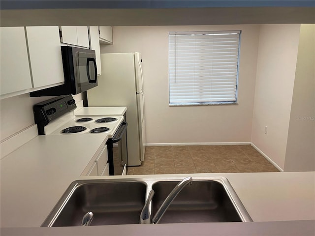 kitchen with black microwave, a sink, white cabinetry, light countertops, and electric range oven