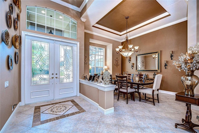 foyer with a chandelier, plenty of natural light, french doors, and a tray ceiling