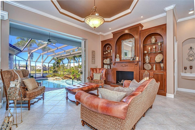 living area with ceiling fan, light tile patterned flooring, crown molding, and a tray ceiling