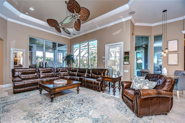 living room featuring ceiling fan, ornamental molding, a high ceiling, and a tray ceiling