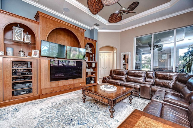 living room featuring a tray ceiling, ceiling fan, and ornamental molding