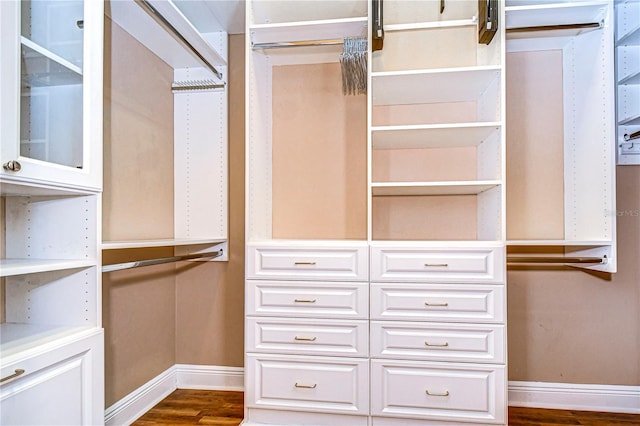 walk in closet with dark hardwood / wood-style flooring