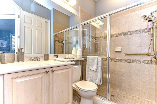 bathroom featuring vanity, toilet, and a shower with shower door