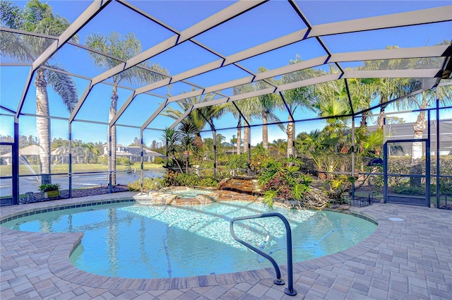 view of pool with a lanai, an in ground hot tub, and a patio