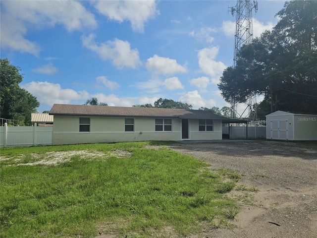 back of house with a shed and a yard