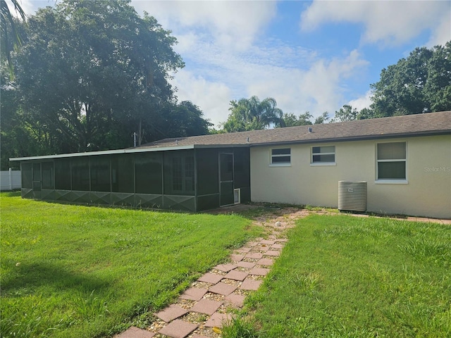 rear view of house with a sunroom and a yard