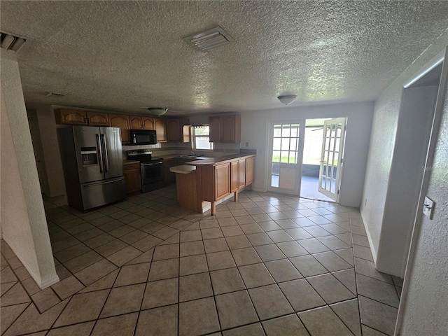 kitchen featuring french doors, a textured ceiling, stainless steel appliances, sink, and light tile patterned flooring