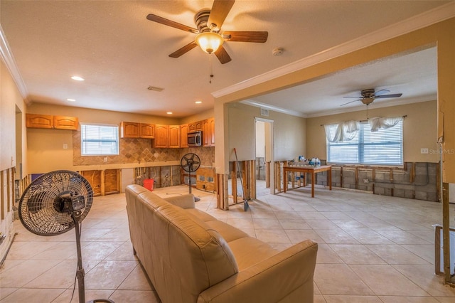 living room with ceiling fan, light tile patterned floors, and ornamental molding