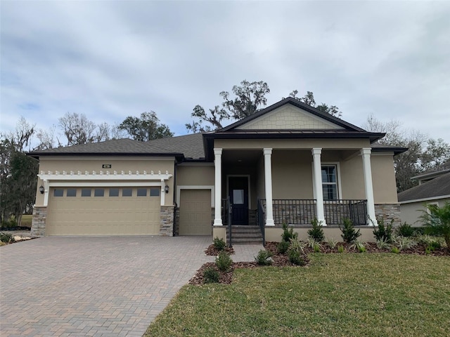 view of front of house featuring a porch, a front yard, and a garage