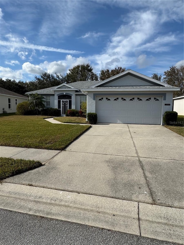 ranch-style house featuring a front lawn and a garage