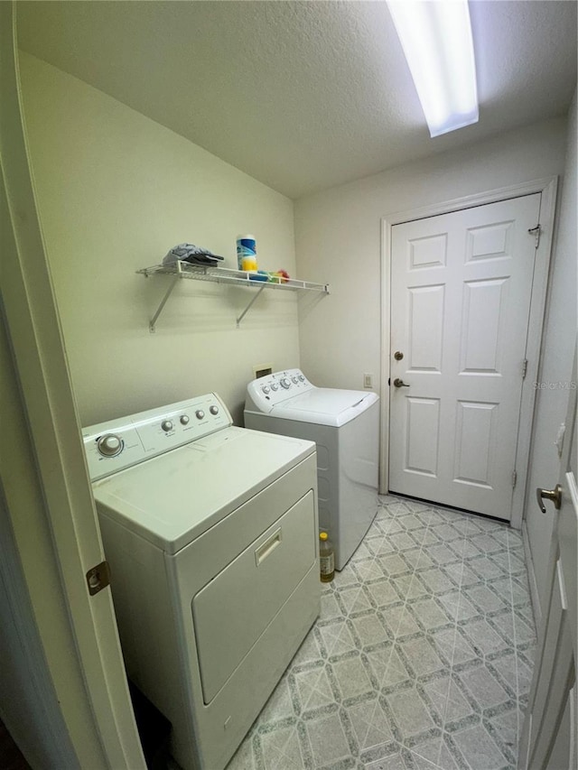 washroom featuring a textured ceiling and independent washer and dryer