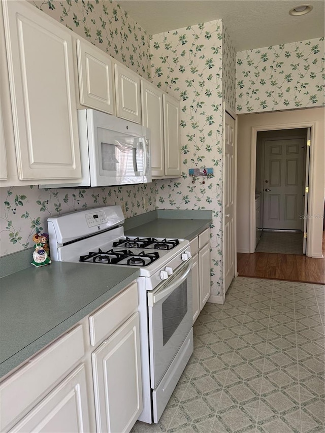 kitchen featuring light hardwood / wood-style flooring, white cabinets, and white appliances