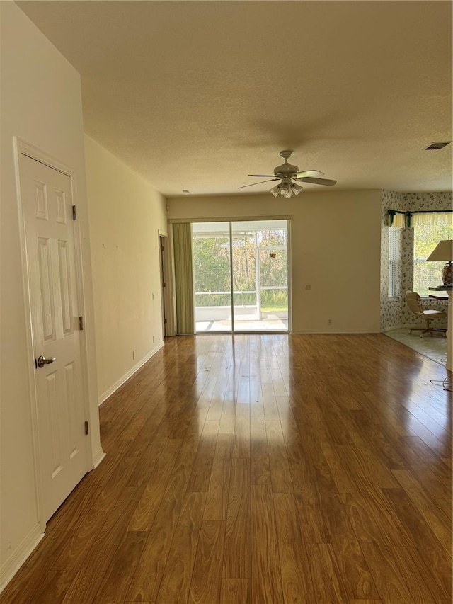 unfurnished room with hardwood / wood-style flooring, ceiling fan, and a textured ceiling