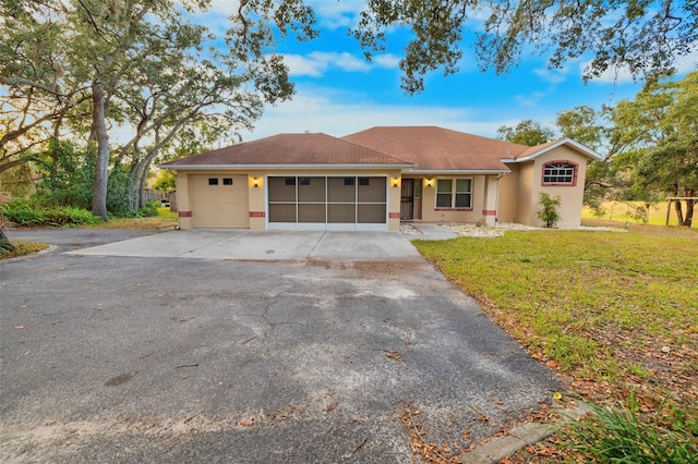 ranch-style house with a garage and a front lawn