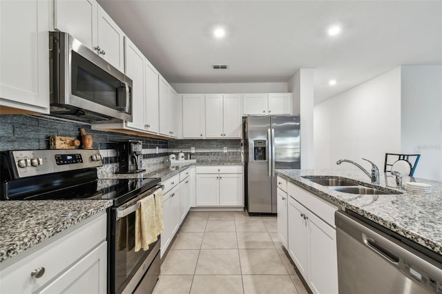 kitchen featuring decorative backsplash, white cabinetry, sink, and stainless steel appliances