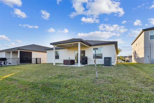 back of property with a lawn, a patio area, and central air condition unit