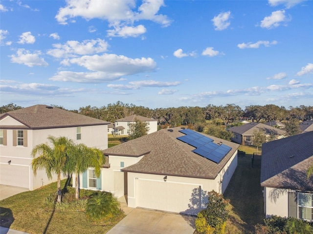 view of front of property featuring a garage and solar panels