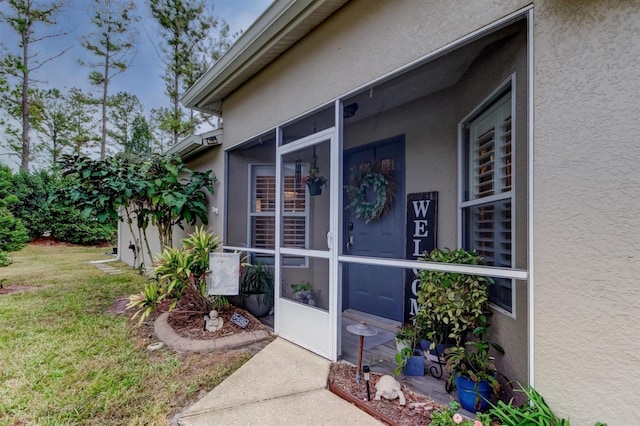 doorway to property with a lawn