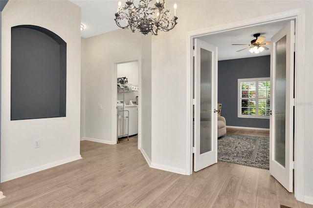 corridor featuring a notable chandelier, washer and clothes dryer, french doors, and light wood-type flooring