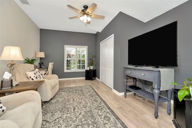 living room with light hardwood / wood-style floors, vaulted ceiling, and ceiling fan