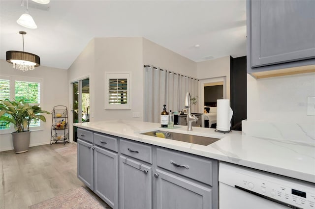 kitchen with light stone counters, light hardwood / wood-style floors, dishwasher, gray cabinets, and hanging light fixtures