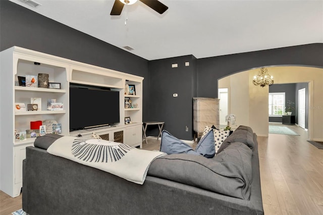 living room featuring ceiling fan with notable chandelier and light hardwood / wood-style floors