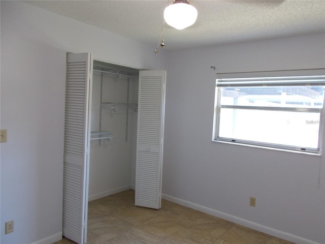 unfurnished bedroom with a textured ceiling and a closet