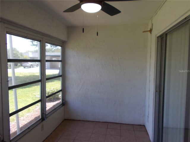 unfurnished sunroom with ceiling fan