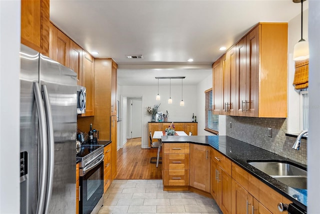 kitchen with sink, pendant lighting, stainless steel appliances, and light wood-type flooring