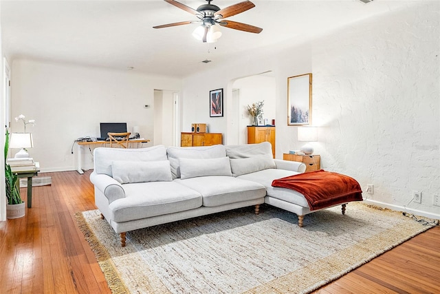 living room featuring wood-type flooring and ceiling fan