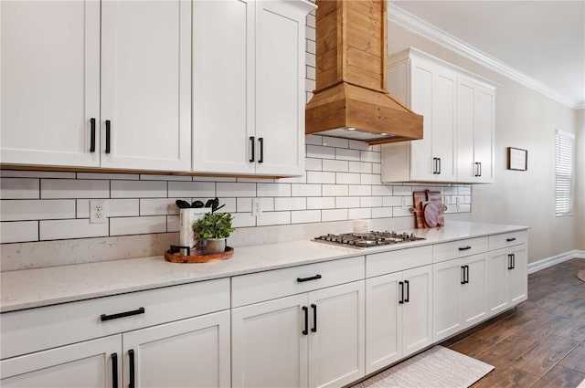 kitchen featuring custom exhaust hood, crown molding, dark hardwood / wood-style floors, white cabinetry, and stainless steel gas cooktop