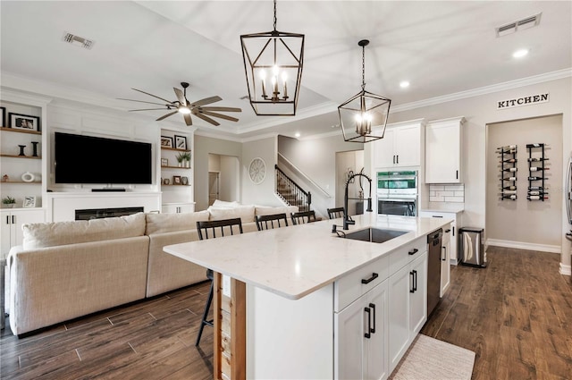 kitchen with white cabinetry, sink, an island with sink, and dark wood-type flooring