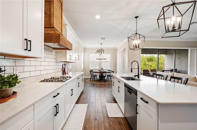 kitchen featuring stainless steel appliances, a kitchen island with sink, dark wood-type flooring, sink, and decorative light fixtures