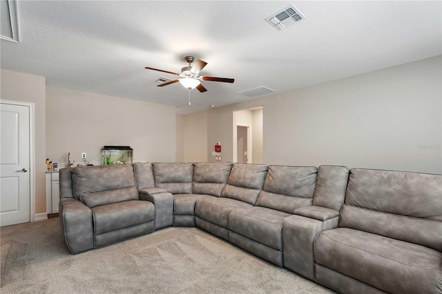 carpeted living room featuring ceiling fan and a textured ceiling