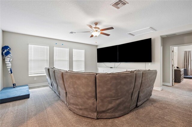 carpeted living room with ceiling fan and a textured ceiling