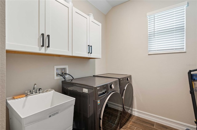 laundry area featuring washer and clothes dryer, dark hardwood / wood-style floors, cabinets, and sink