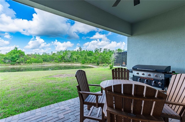 view of patio with area for grilling, ceiling fan, and a water view