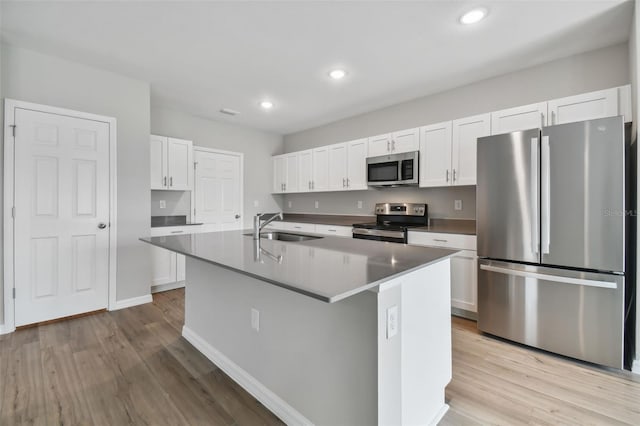 kitchen with sink, stainless steel appliances, an island with sink, light hardwood / wood-style floors, and white cabinets