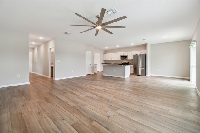 unfurnished living room with light wood-type flooring and ceiling fan