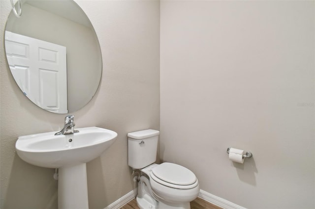 bathroom with hardwood / wood-style floors and toilet